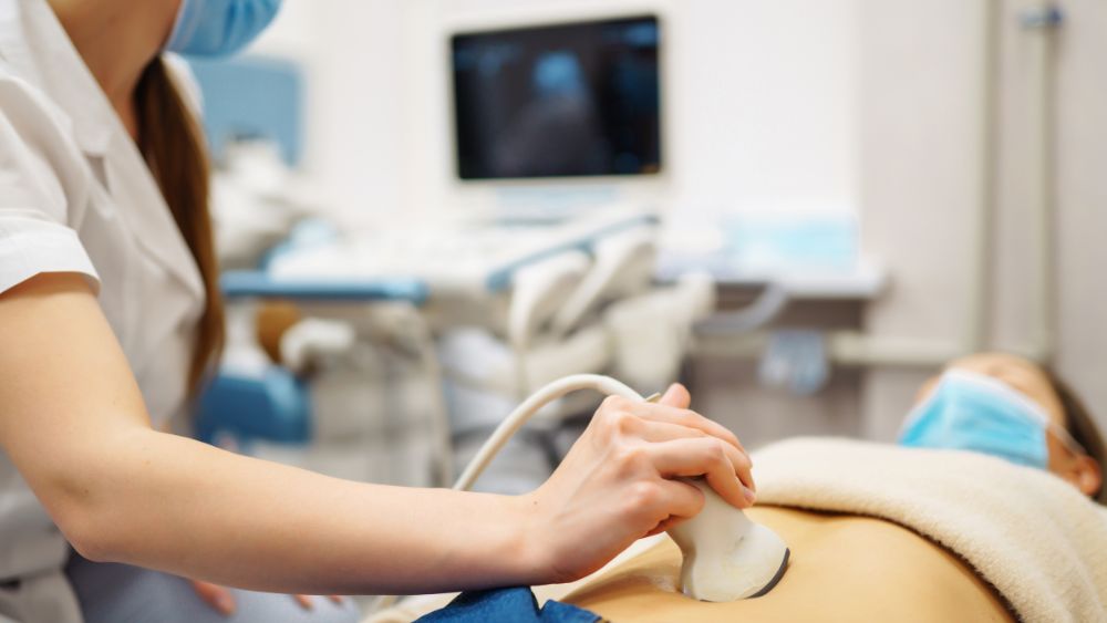 Doctor Performing Ultrasound Using Transducer On Pregnant Abdomen - NRKSS Blog